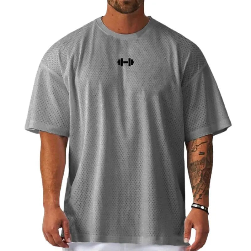 Camiseta oversized masculina cinza com ícone de halter preto no peito, modelo respirável para academia